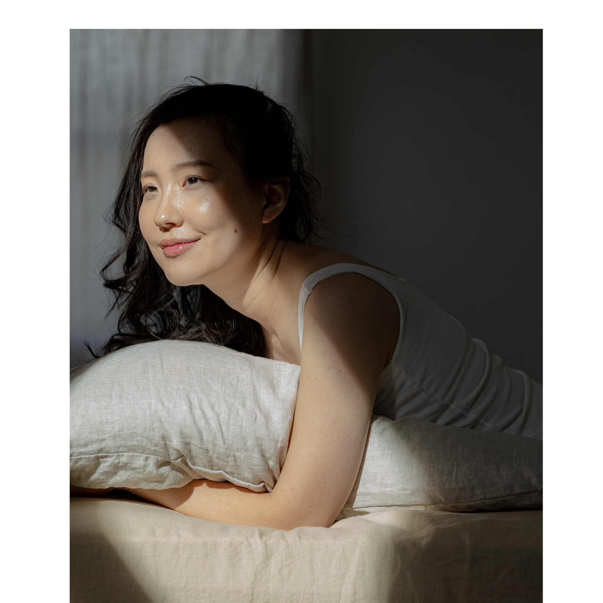 Woman lying on a bed with soft lighting