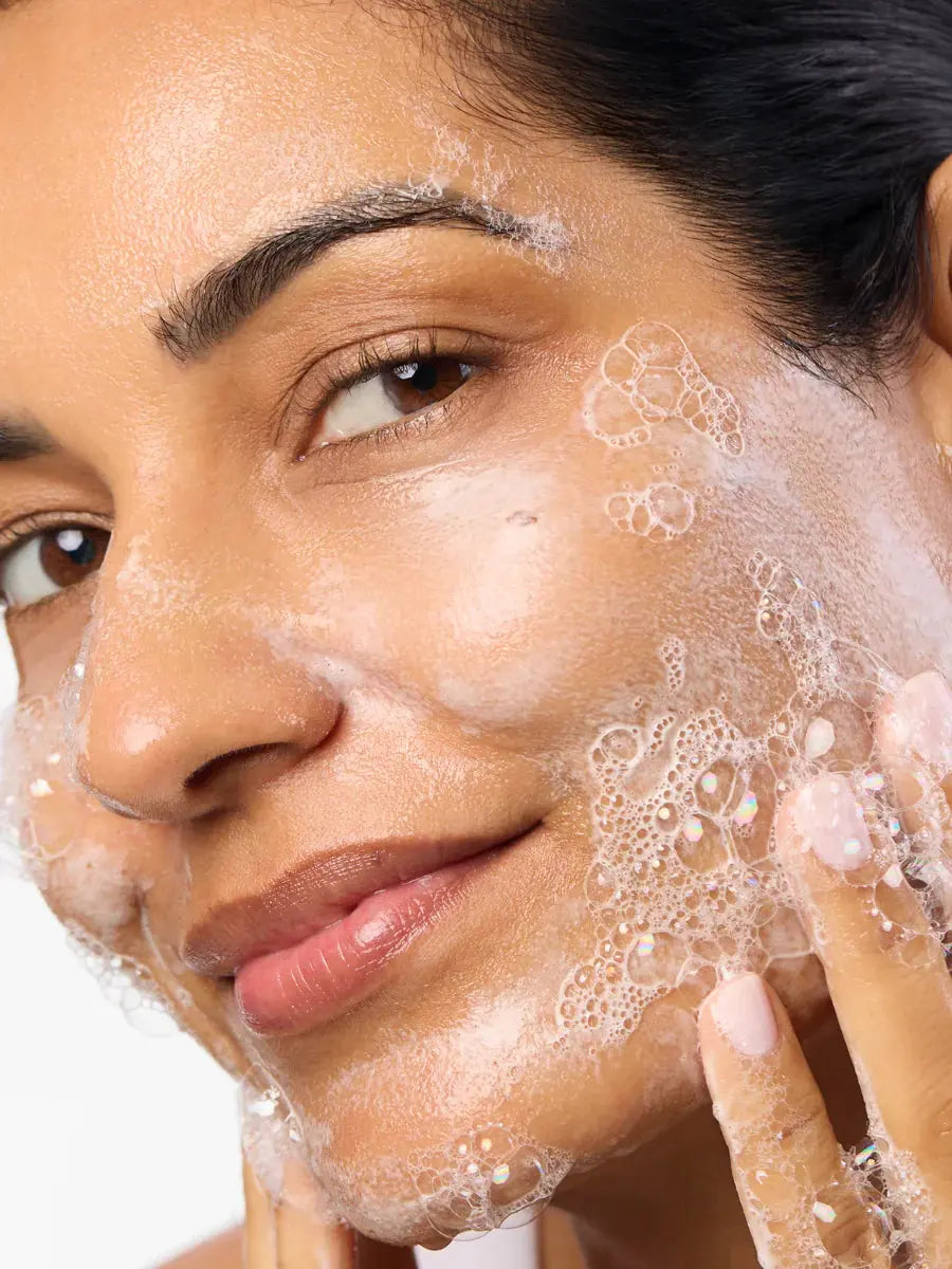 Women washing face with Aura foaming cleanser