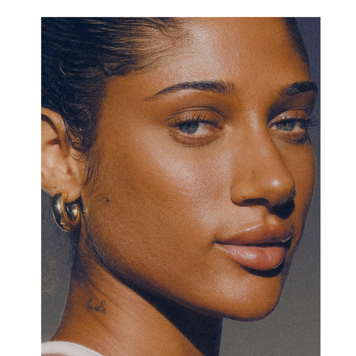 Close-up of a woman's face with blue eyes and gold earring