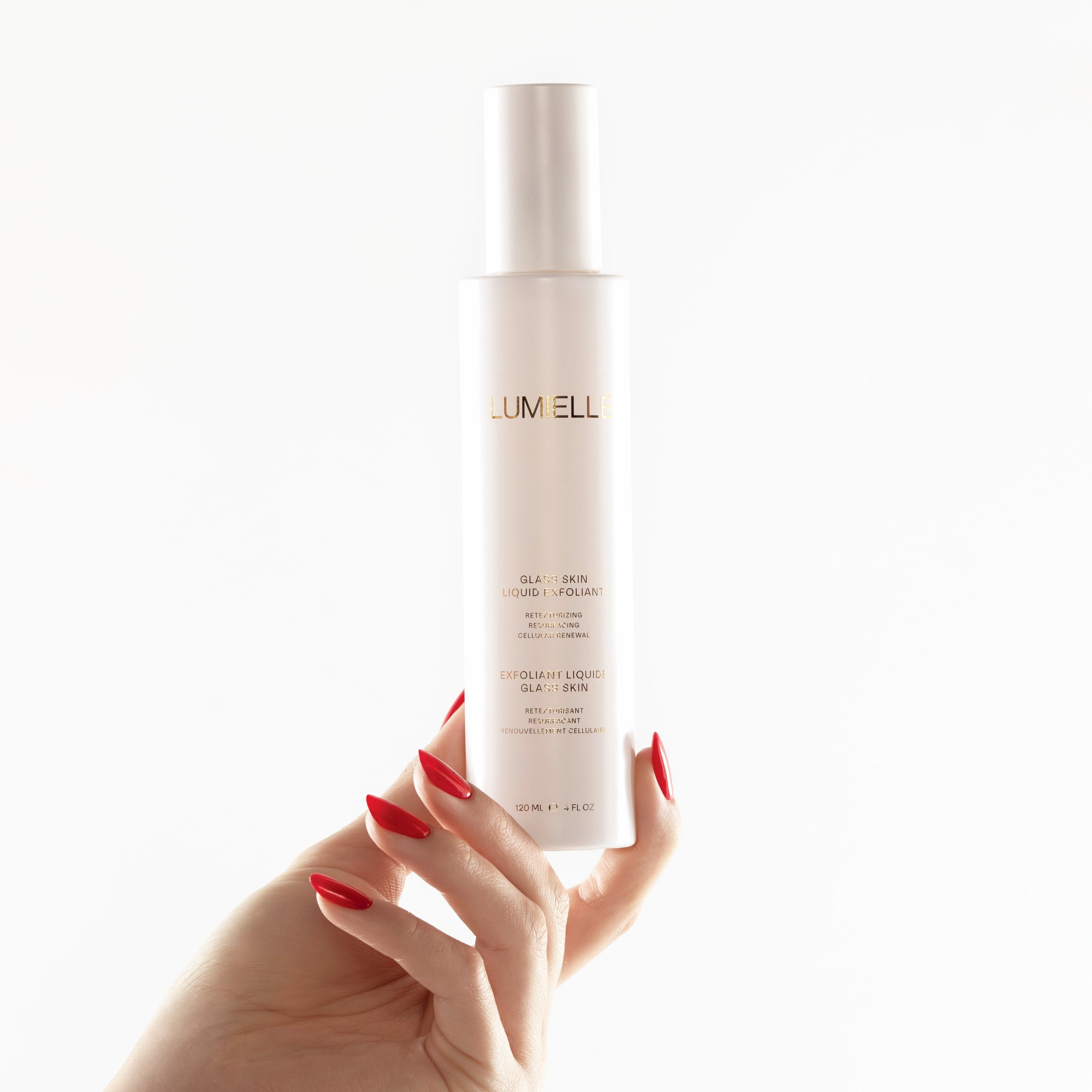 A hand holding a bottle of Glass Skin Liquid Exfoliant with a white pump dispenser.