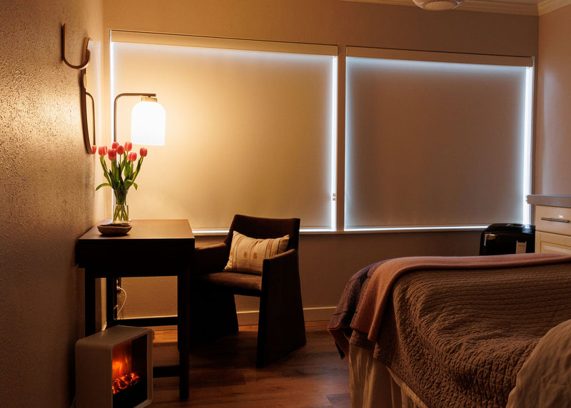 Cozy bedroom with bed, desk, and lamp in a warm setting