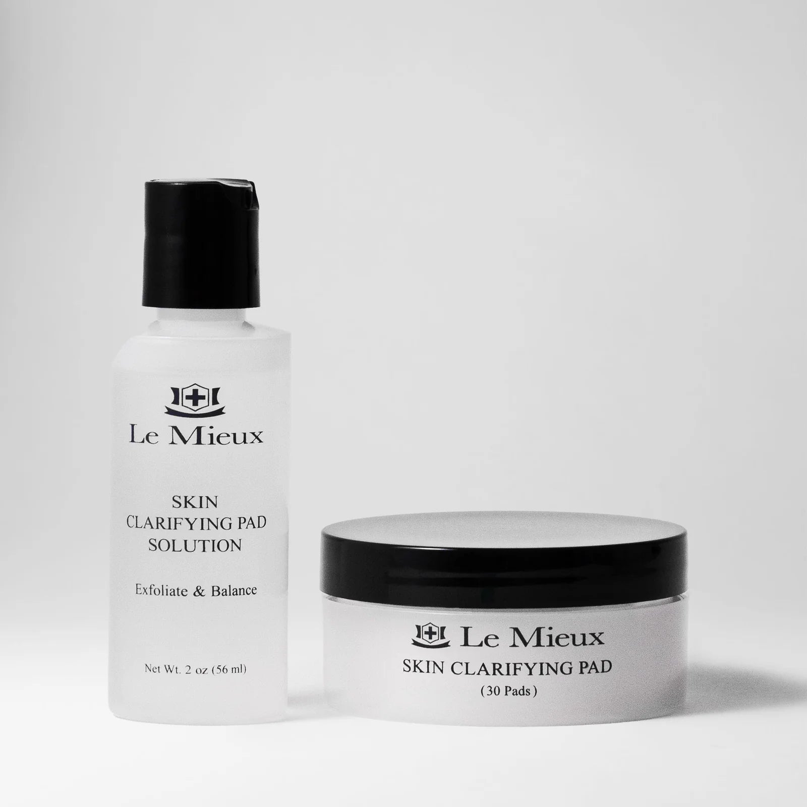 Skin clarifying pad solution in bottle and jar with white background