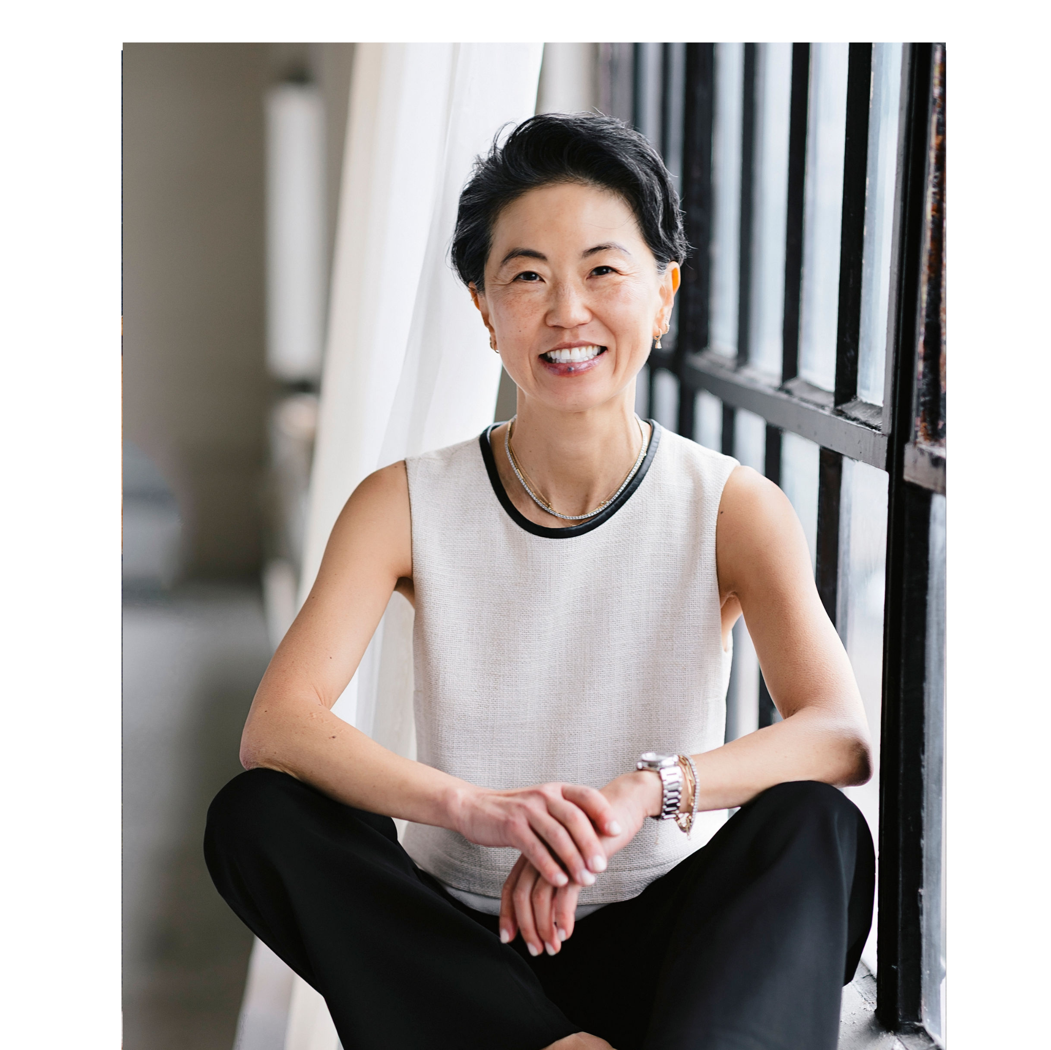 Woman sitting indoors with a neutral background